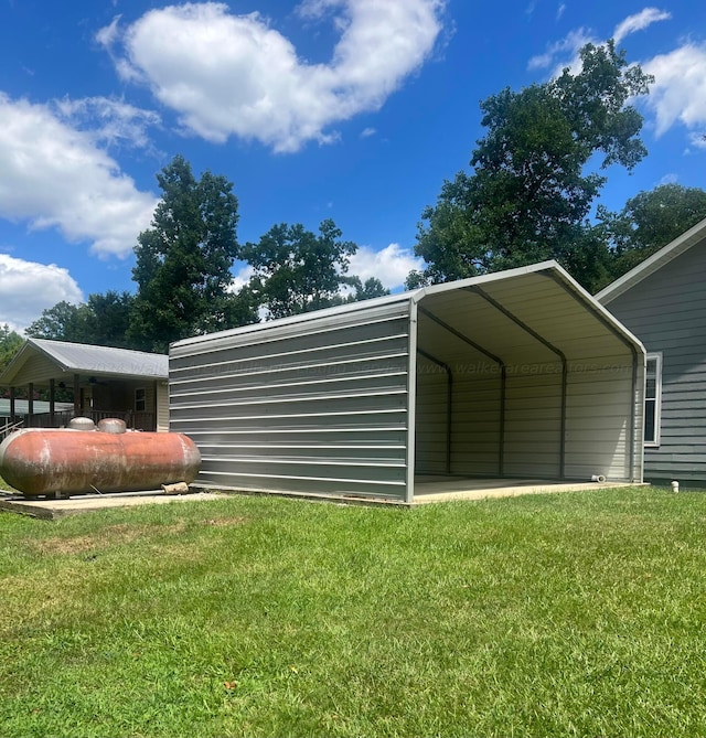 view of outdoor structure with a yard and a carport