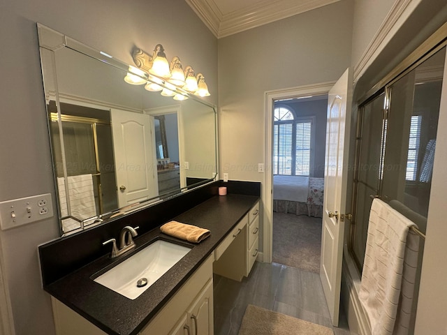 bathroom featuring vanity, a shower with shower door, and ornamental molding