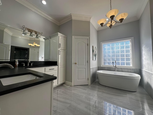 bathroom featuring crown molding, vanity, a bathtub, and a notable chandelier