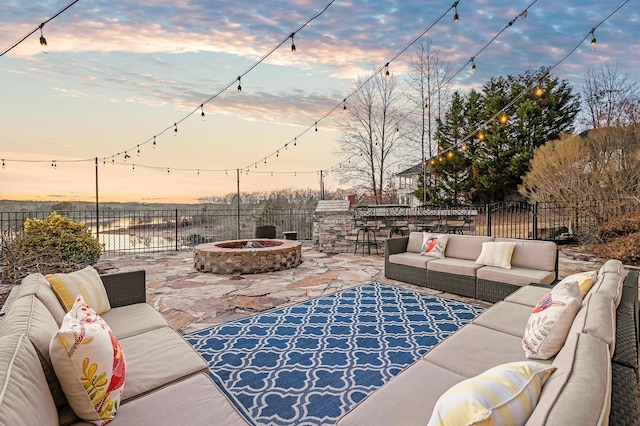 patio terrace at dusk with an outdoor living space with a fire pit