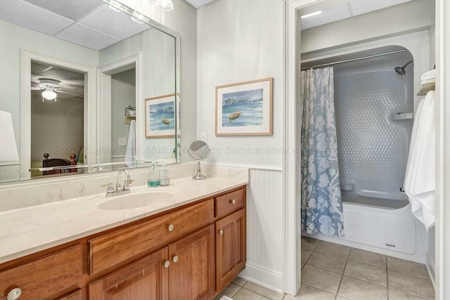 full bath with a drop ceiling, shower / bath combo, wainscoting, tile patterned floors, and vanity