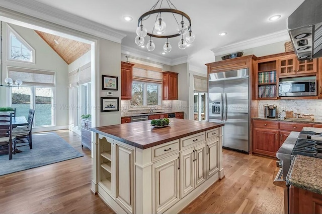 kitchen with open shelves, stainless steel appliances, an inviting chandelier, butcher block counters, and light wood finished floors