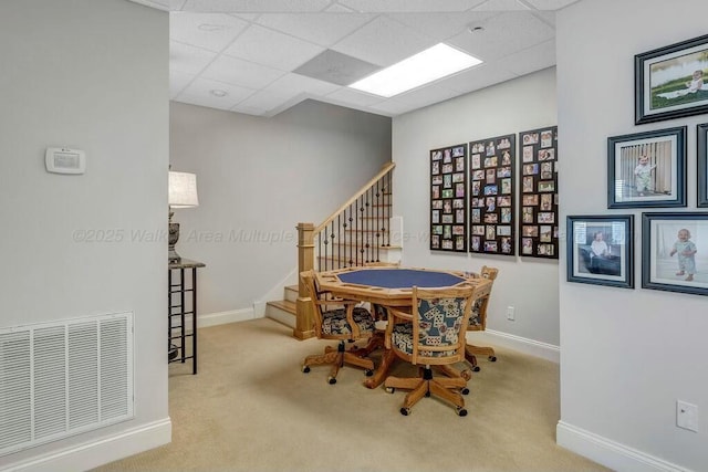 dining room featuring visible vents, a drop ceiling, stairway, carpet, and baseboards