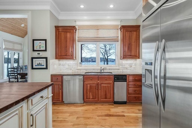 kitchen with plenty of natural light, light wood-type flooring, appliances with stainless steel finishes, and a sink