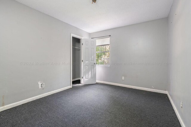 unfurnished bedroom with a closet, carpet floors, and a textured ceiling