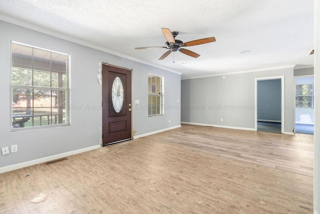 entryway featuring ceiling fan, ornamental molding, a textured ceiling, and light wood-type flooring