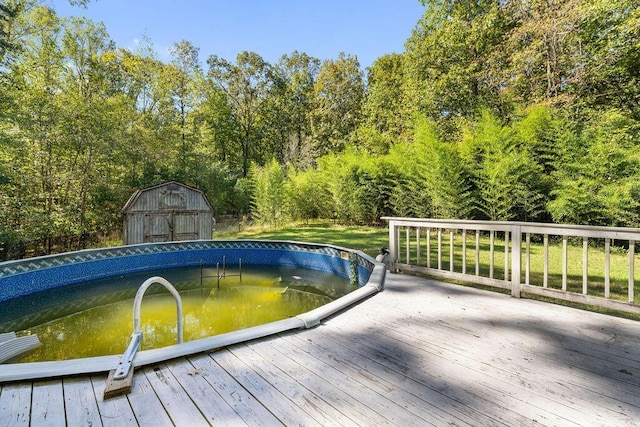 view of swimming pool featuring a deck with water view and a storage shed