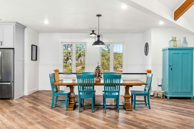 dining area with light hardwood / wood-style flooring and beam ceiling