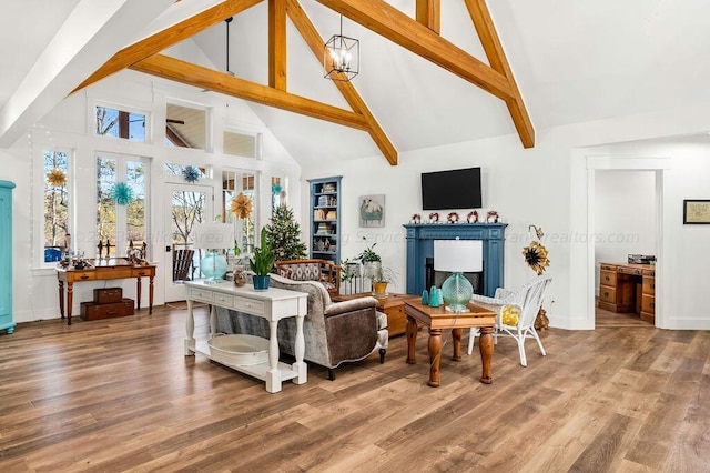 living room featuring wood-type flooring, beam ceiling, high vaulted ceiling, and a notable chandelier