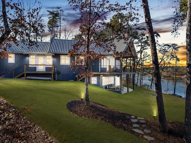 yard at dusk featuring a water view