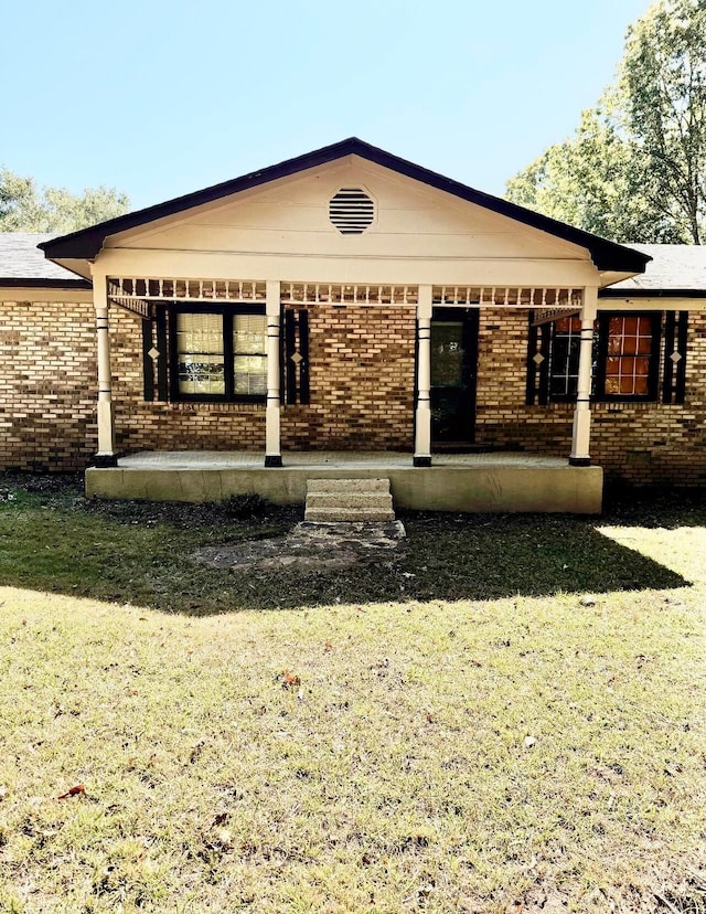 rear view of property with a lawn and covered porch