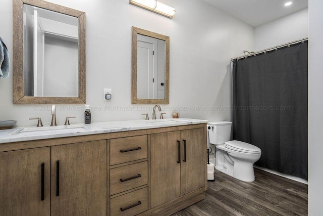 bathroom featuring toilet, hardwood / wood-style flooring, and vanity