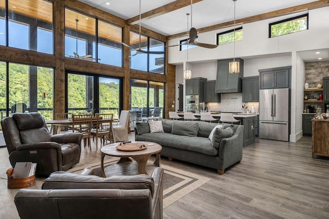 living room with french doors, ceiling fan, hardwood / wood-style floors, and a high ceiling