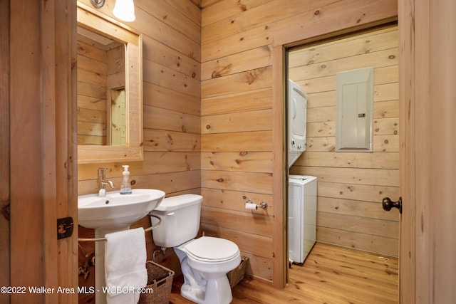 bathroom featuring wood walls, toilet, and hardwood / wood-style flooring