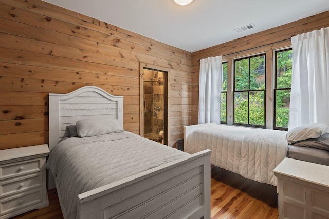 bedroom with wood walls and wood-type flooring