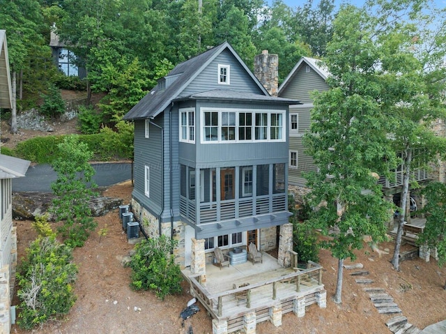 rear view of house featuring central AC