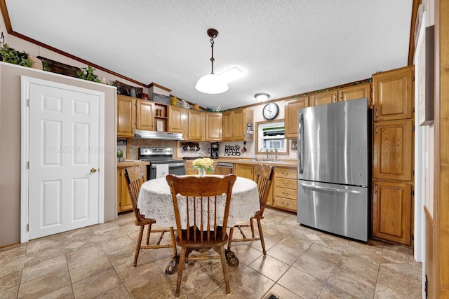 kitchen with crown molding, pendant lighting, a textured ceiling, vaulted ceiling, and appliances with stainless steel finishes