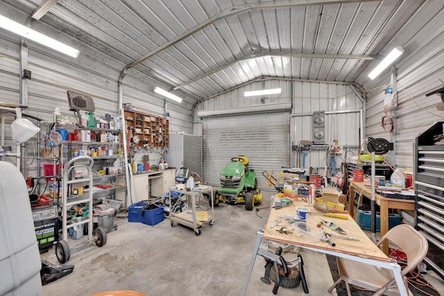 garage with a workshop area and wood walls