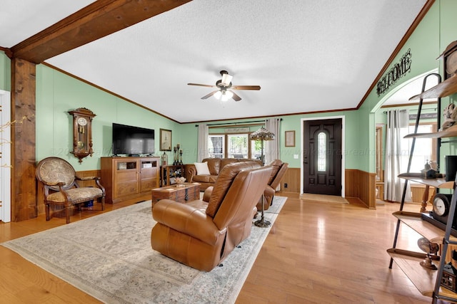 living room featuring a textured ceiling, light hardwood / wood-style flooring, and vaulted ceiling