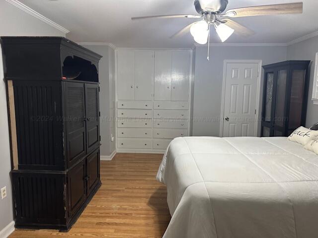 bedroom with ceiling fan, light wood-type flooring, and crown molding