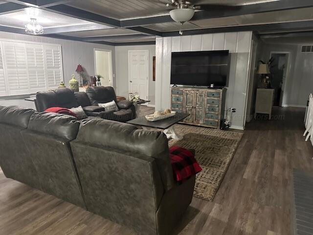 living room featuring beamed ceiling, hardwood / wood-style floors, ceiling fan with notable chandelier, and coffered ceiling