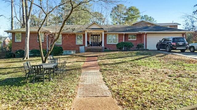 ranch-style house with a garage and a front lawn