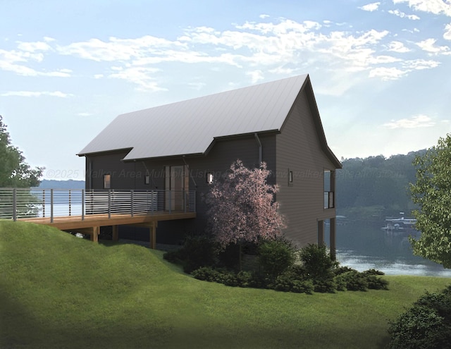 rear view of house featuring metal roof, a yard, and a water view