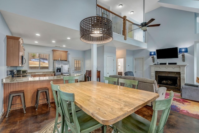 dining area featuring a towering ceiling and ceiling fan