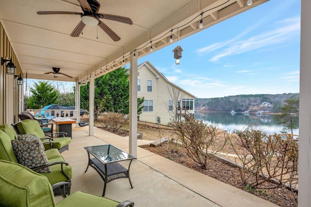 view of patio featuring a water view, ceiling fan, and an outdoor hangout area