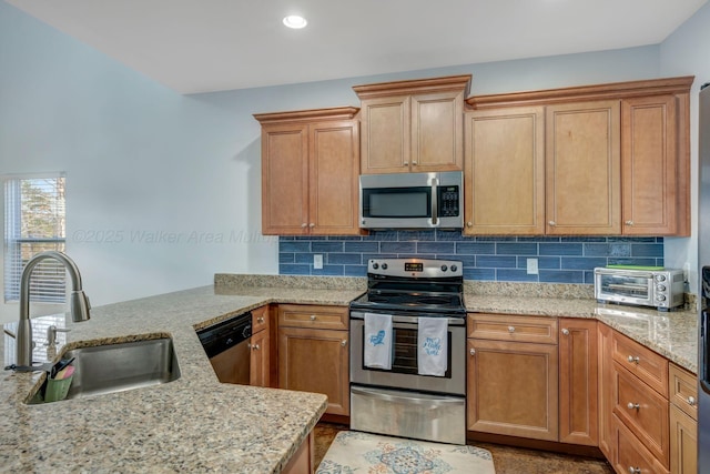 kitchen featuring light stone countertops, appliances with stainless steel finishes, sink, and backsplash