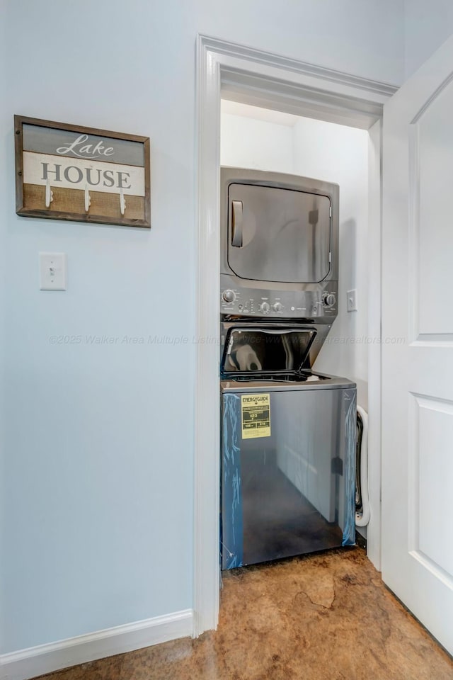 clothes washing area featuring stacked washer and clothes dryer