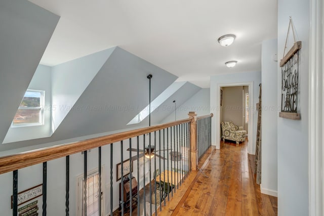 hall featuring wood-type flooring and vaulted ceiling