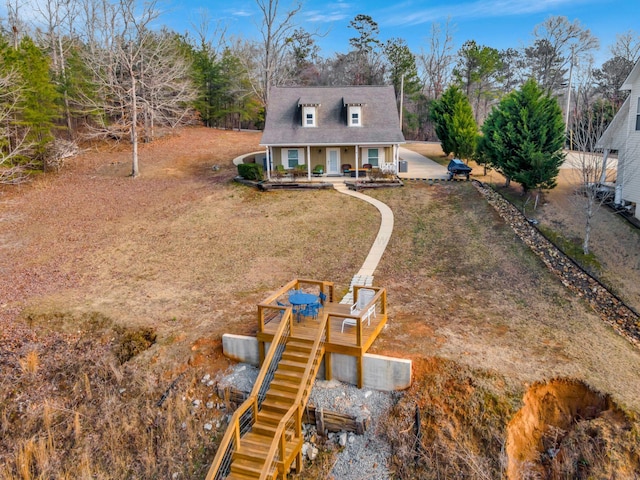 rear view of property with a porch and a lawn