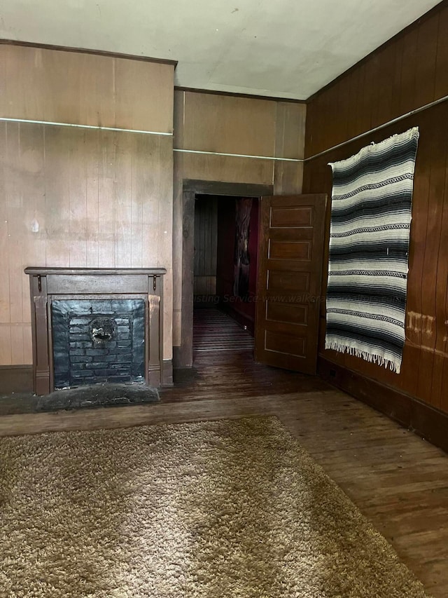 unfurnished living room with wood walls and dark hardwood / wood-style floors