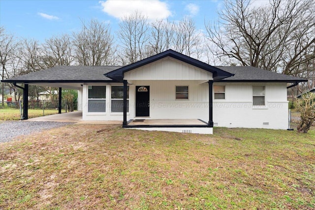 ranch-style home featuring a carport and a front lawn