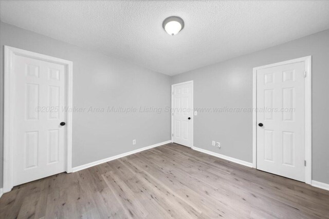 empty room featuring wood-type flooring and a textured ceiling