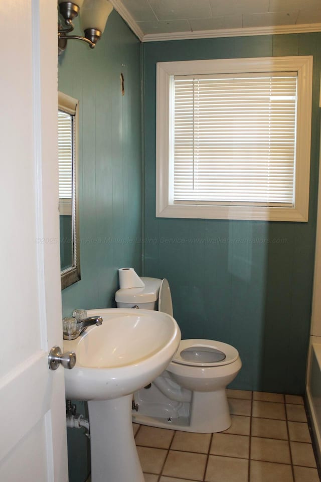 bathroom featuring crown molding, toilet, a bathing tub, tile patterned floors, and plenty of natural light