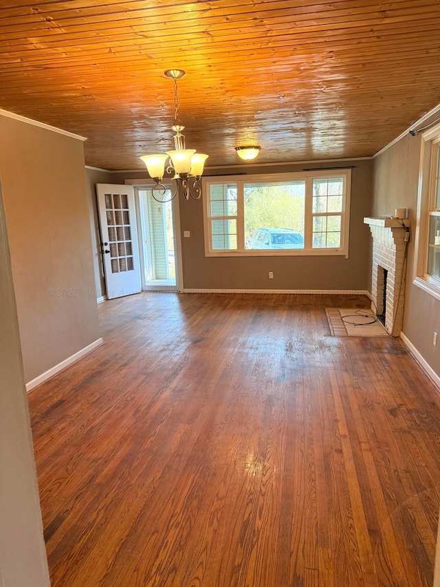 unfurnished living room featuring an inviting chandelier, dark wood-style flooring, wood ceiling, crown molding, and a brick fireplace