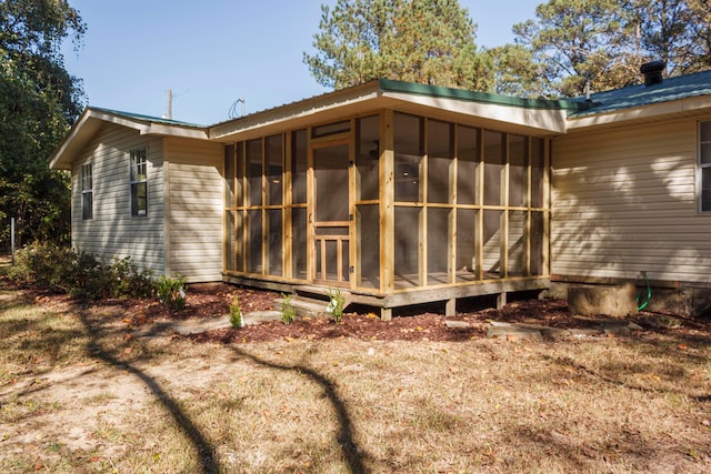 view of property exterior with a sunroom