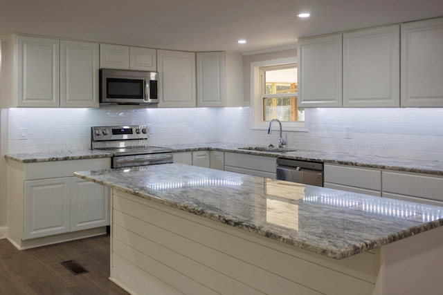 kitchen featuring white cabinetry, sink, dark hardwood / wood-style flooring, decorative backsplash, and appliances with stainless steel finishes