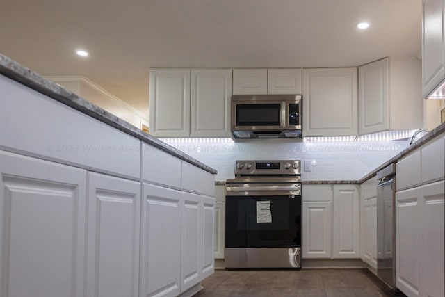 kitchen featuring decorative backsplash, appliances with stainless steel finishes, white cabinetry, and stone counters