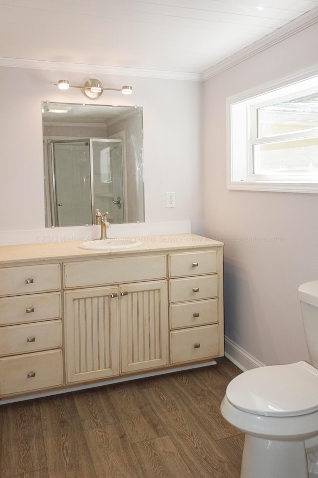 bathroom with crown molding, wood-type flooring, an enclosed shower, toilet, and vanity