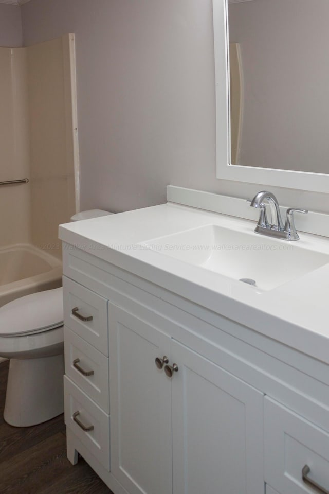 full bathroom featuring shower / bathing tub combination, wood-type flooring, vanity, and toilet