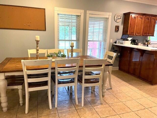 dining area featuring crown molding and light tile patterned flooring