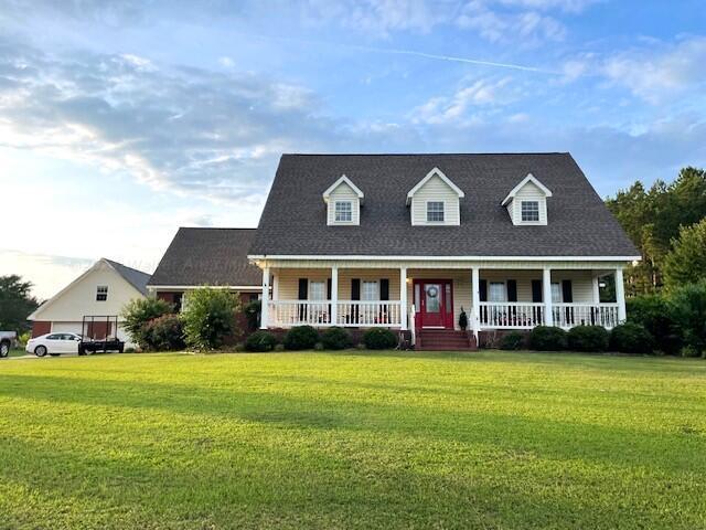 cape cod home featuring a front lawn