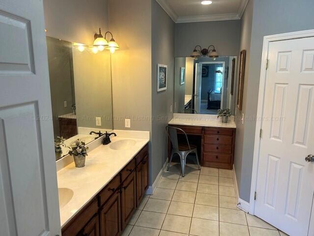 bathroom featuring tile patterned flooring, vanity, and crown molding