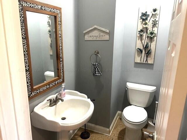 bathroom featuring toilet, tile patterned flooring, and sink