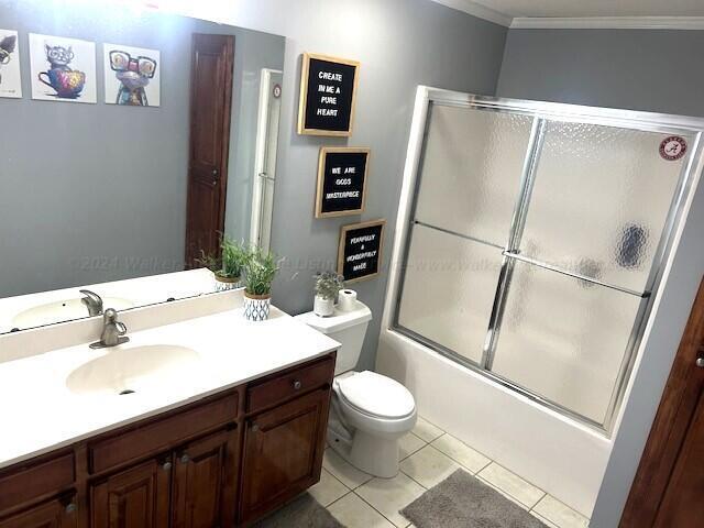 full bathroom featuring ornamental molding, vanity, enclosed tub / shower combo, tile patterned flooring, and toilet