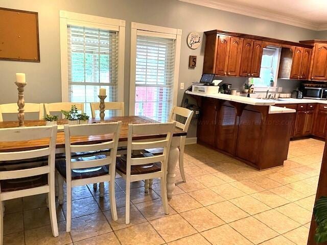 kitchen with light tile patterned flooring, ornamental molding, and sink