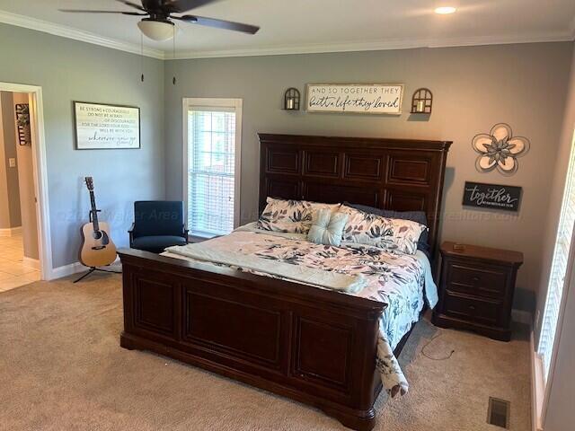 bedroom with light colored carpet, ceiling fan, and ornamental molding